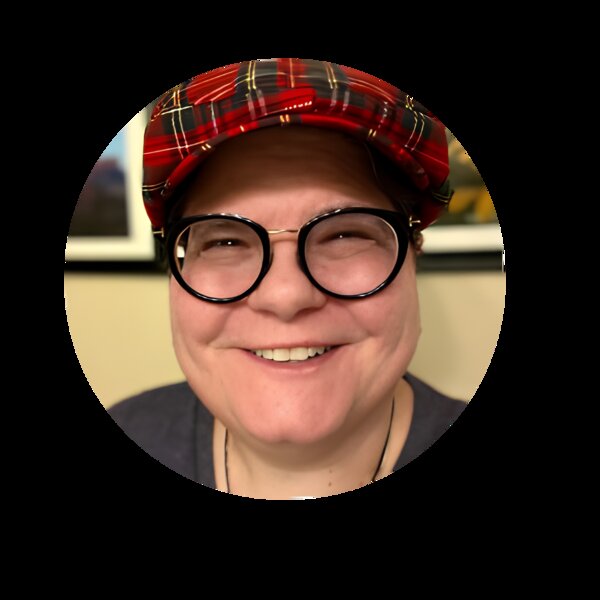 Ashwani — a smiling person wearing a red plaid flat cap and round black-rimmed glasses, radiating warmth and approachability