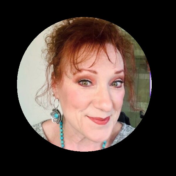 Lezli Hall, the Purple Rose Psychic — a woman with warm auburn hair and turquoise jewelry, smiling with kind green eyes