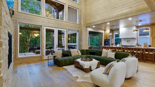 Open-concept great room with vaulted ceilings and a green sectional sofa