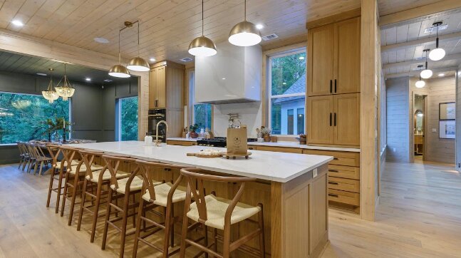 Chef's kitchen with a long marble island and pendant lighting